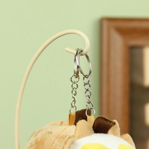 Détail du porte-clés en métal argenté et texture peluche douce sur le charme de sac