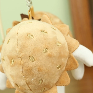 Vue détaillée du porte-clés peluche fruit du dragon avec broderie dorée et tissu doux
