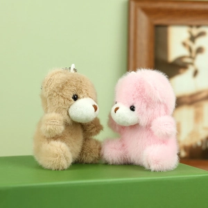 Detail van roze en lichtbruine teddybeer pluche sleutelhangers met metalen kettingen