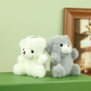 Close-up van witte en grijze pluche teddybeer hangers met zachte vacht en kettingen