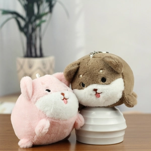 Close-up of cute pink and brown plush dog keychains with embroidery on a wooden table