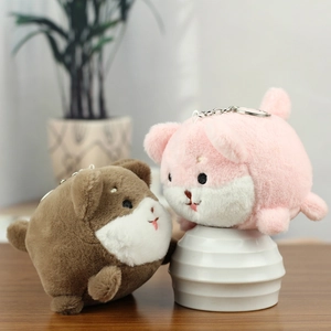 Close-up of pink and brown plush puppy keychains with soft texture and metal rings