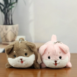 Close-up of brown and pink Shiba Inu plush charms with silver keychains and embroidery