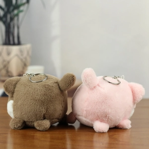 Close-up of soft pink and brown plush puppy keychains with fluffy texture and metal rings