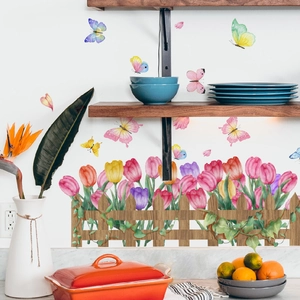 Watercolor floral wall sticker with tulips, butterflies and a wooden fence on a white wall