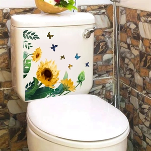 Dettaglio di adesivi con girasoli e farfalle su un serbatoio per WC in ceramica bianca