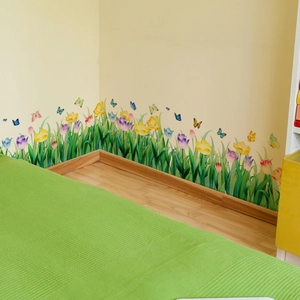 Detailed view of self-adhesive tulip flower wall stickers on a room baseboard