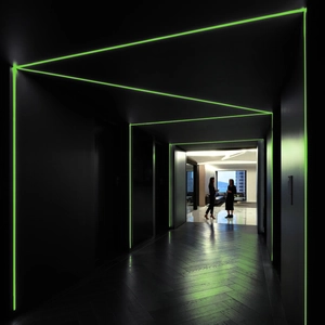 Luminous green linear LED strip light decorating corridor wall edges and baseboards