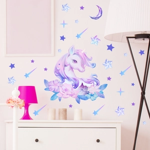 Detailed view of glowing unicorn and moon wall stickers on a pink bedroom wall