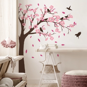 Detail of cherry blossom wall decal with pink petals and birds on a living room wall