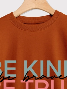 Detail of ribbed neckline and colorful slogan prints on rust red cotton sweatshirt