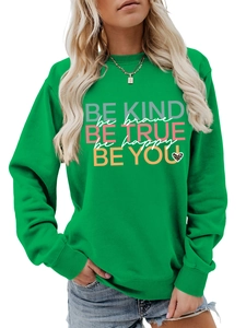 Detail of green crewneck sweatshirt featuring Be Kind and Be Brave text prints