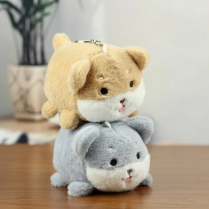 Close-up of cute plush dog keychains in brown and grey on a rustic wooden table