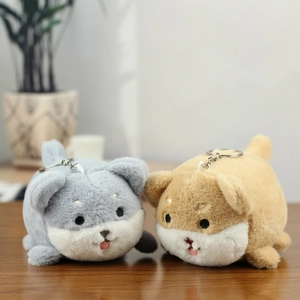 Close-up of cute plush Shiba Inu keychains on a wooden surface with metal rings