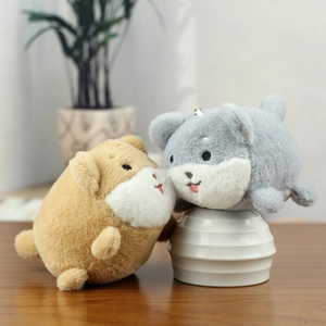 Close-up of cute plush dog and hamster keychain pendants in khaki and grey on a stand