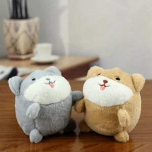 Close-up of two cute plush animal charms in blue and yellow on a rustic wooden desk