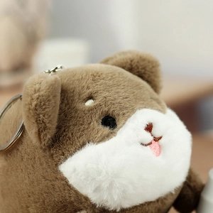 Macro shot of fluffy plush dog keychain showing soft brown fur and detailed embroidery