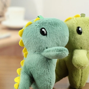 Détails macro de porte-clés dinosaures en peluche douce, coloris bleu et vert tendre