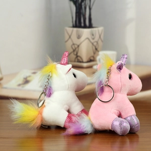 Close-up of pink and white plush unicorns with sequin horns and metal keychains