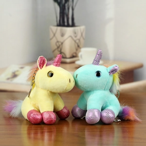 Detail of candy-colored plush unicorns with rainbow manes and glittery accents on wood