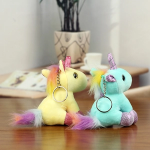 Detail of yellow and mint plush unicorns with rainbow manes and shiny silver keyrings