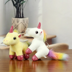 Close-up of fluffy unicorn plush keychains with rainbow manes and glitter details