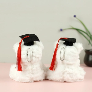 Rear view of two white plush graduation bears with black caps and red tassels