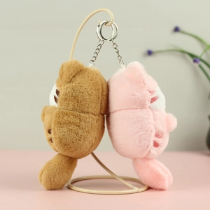 Detailed plush cat pendants in pink and brown colors hanging on a metal stand