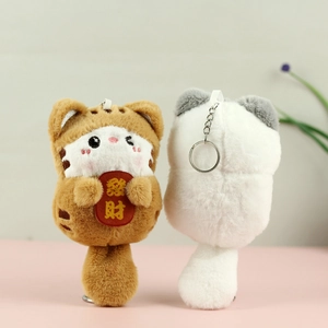 Close-up of cute plush tiger and cat keychain with lucky red tag and metal ring