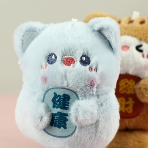 Detail of blue plush cat charm with soft texture and health embroidery on its belly