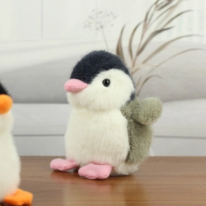 Close-up of cute plush penguin keychain with soft grey and olive green fur texture