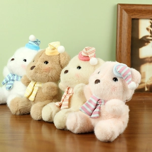 Detail of four colorful plush teddy bears with striped hats and scarves on a wooden table