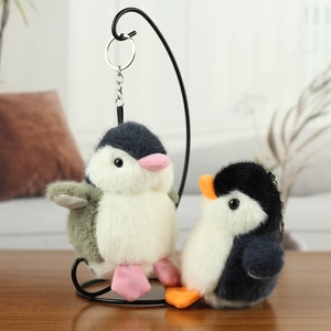Detailed view of plush penguin pendants with soft long fur and metallic keychains