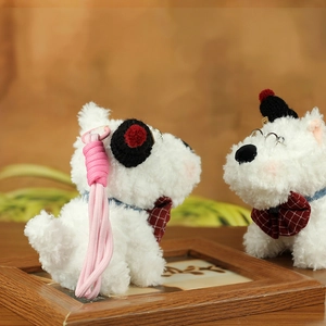 Detail of Westie plush keychain with round glasses, knit hat and checkered bow tie charm