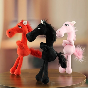 Three plush horses in red, black, and pink colors standing on a wooden table in detail