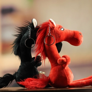 Macro shot of long-neck plush horse charms with embroidery and metal keychains
