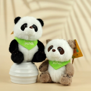 Detailopname van schattige zwarte en bruine panda knuffels met groene sjaals en zacht bont
