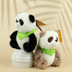 Detail van pluche panda-sleutelhangers in zwart en bruin met groene sjaals en labels