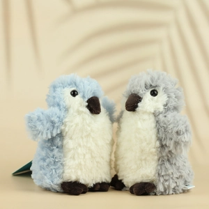Close-up of soft plush penguin dolls in sky blue and grey with fluffy fur textures
