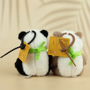 Close-up van pluizige panda pluche sleutelhangers met groene linten en haken