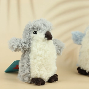 Macro shot of fluffy grey penguin plush with soft fur textures and a retail brand tag