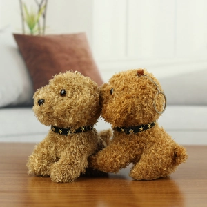 Detailed close-up of fluffy plush poodle keychains with star collars on a wooden desk