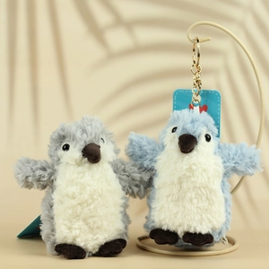 Detail of plush penguin keychains showing soft fur texture and gold metal clasp
