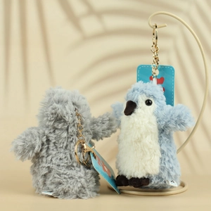Close-up of cute plush penguin keychains with golden metal clips and brand tags