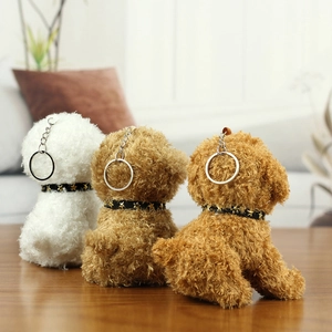 Detailed view of plush poodle keychains in white and brown fur on a wooden table