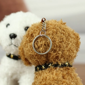 Detail of plush dog keychain featuring brown curly fur and star studded collar charm