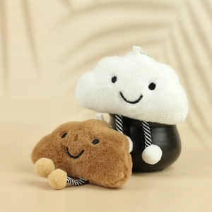 Close-up of cute white and brown plush cloud keychains with striped rope legs