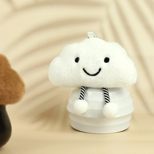 Detail of soft white cloud plush keychain with embroidered face and striped legs