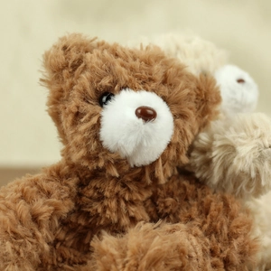 Macro detail of curly plush teddy bear showing soft texture and cute facial features