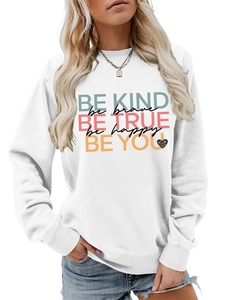 Close-up of white sweatshirt featuring colorful Be Kind typography and leopard heart print